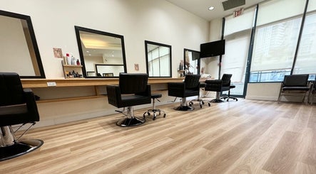 Spacious interior of CuE Hair Salon Vancouver with modern chairs and mirrors, located in Vancouver, British Columbia, CA.