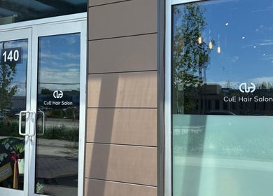 Entrance of CuE Hair Salon Richmond, showcasing modern glass doors, Richmond, British Columbia, CA.