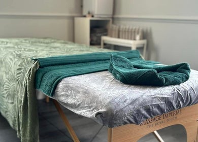 Massage table at Vanity Fayre in Donington, England, GB, adorned with elegant green towels.