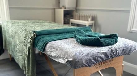 Massage table at Vanity Fayre in Donington, England, GB, adorned with elegant green towels.