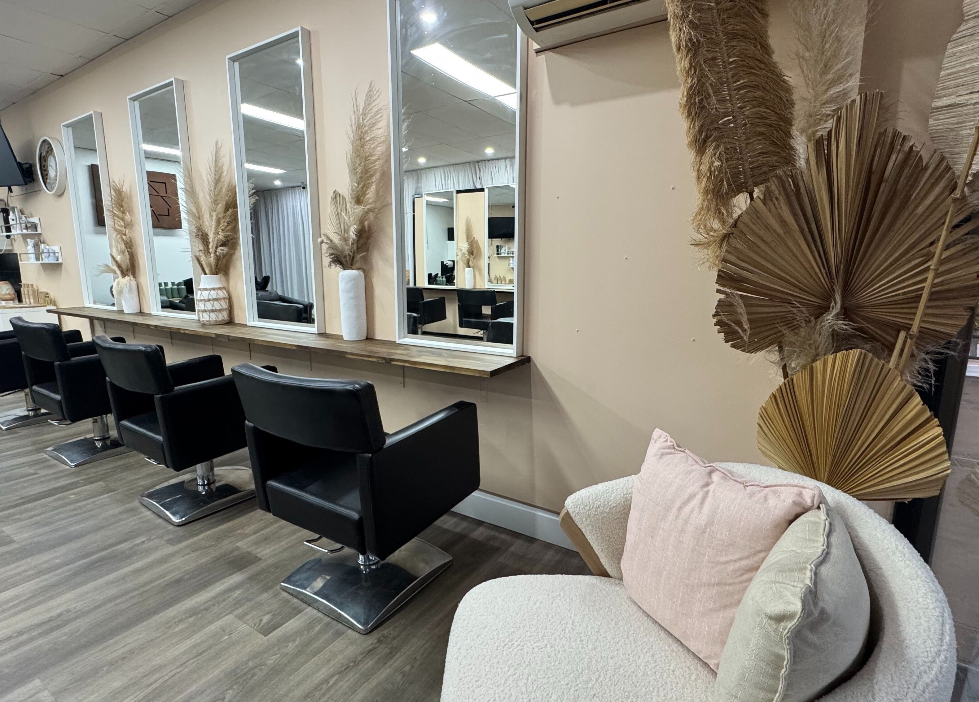 Modern salon interior at Amour Hair, Wyong, New South Wales, AU, with stylish chairs and mirrors.