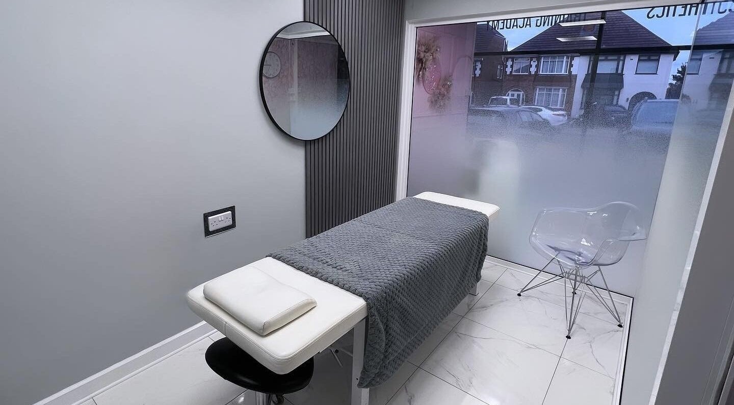 Modern treatment room at You Little Beauty, Birmingham, England, GB with a cozy bed and mirror.