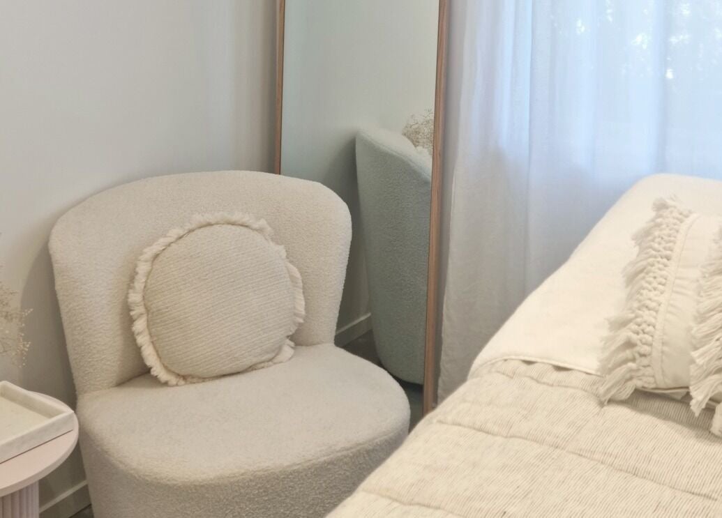 Cozy white seating area in Room of Beauty, Papamoa, Bay Of Plenty, NZ with plush chair and modern decor.