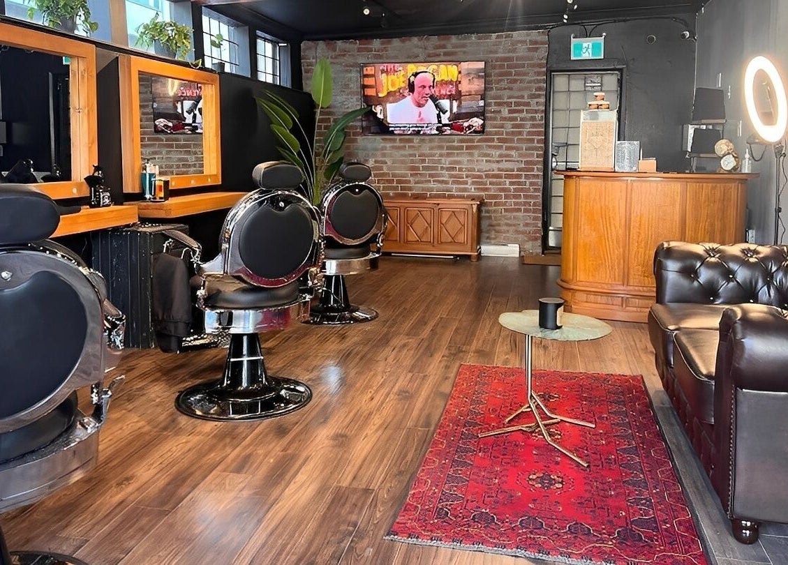 Interior of HEstory Barbershop in Vancouver, BC, featuring stylish chairs and a cozy ambience.