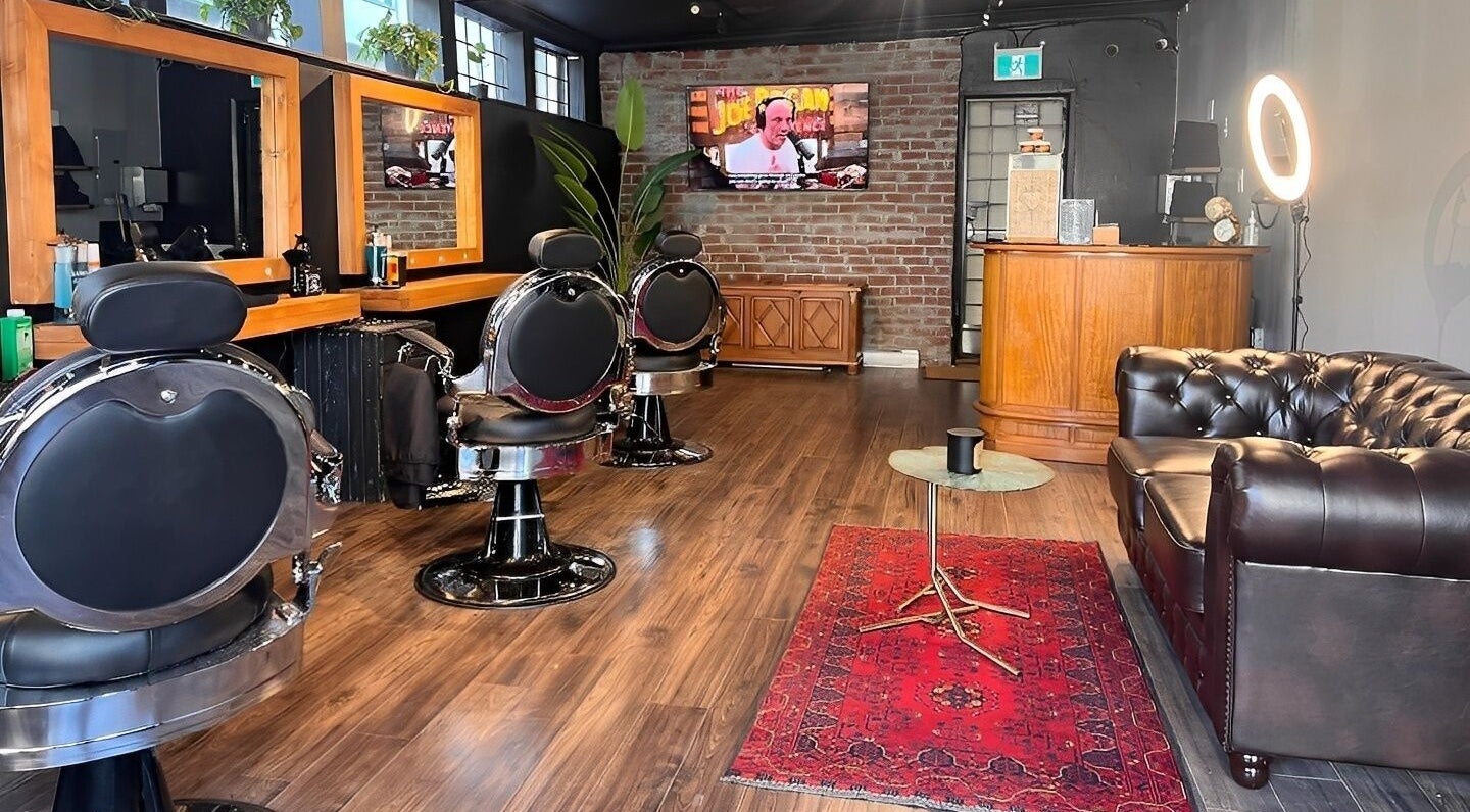 Interior of HEstory Barbershop in Vancouver, BC, featuring stylish chairs and a cozy ambience.