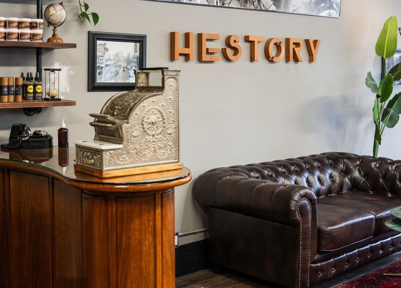 HEstory Barbershop chic lounge in Vancouver, BC with vintage decor and leather sofa.