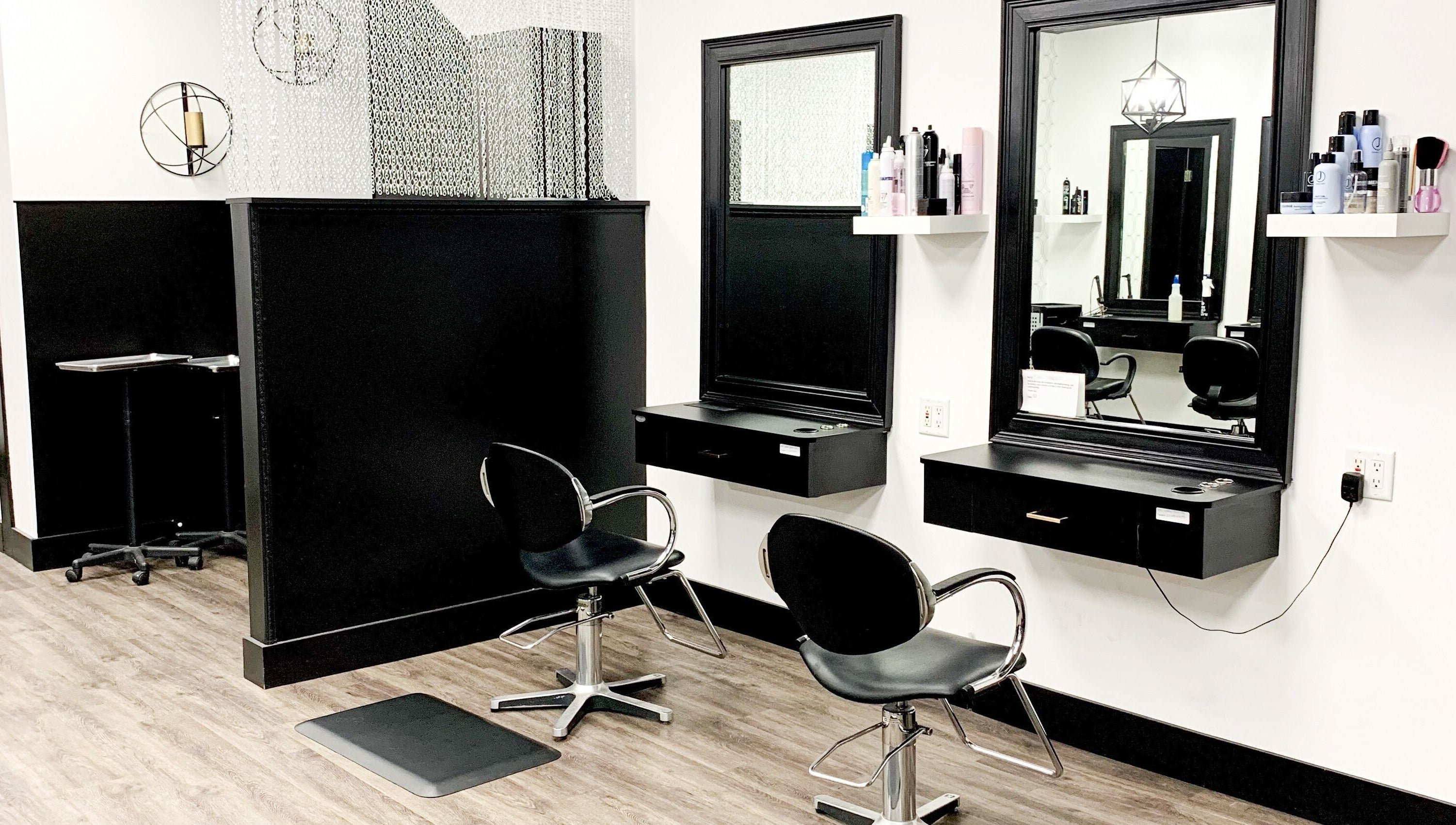 Modern salon setup at Contagious Studio in Abbotsford, British Columbia, CA with stylish black chairs and mirrors.