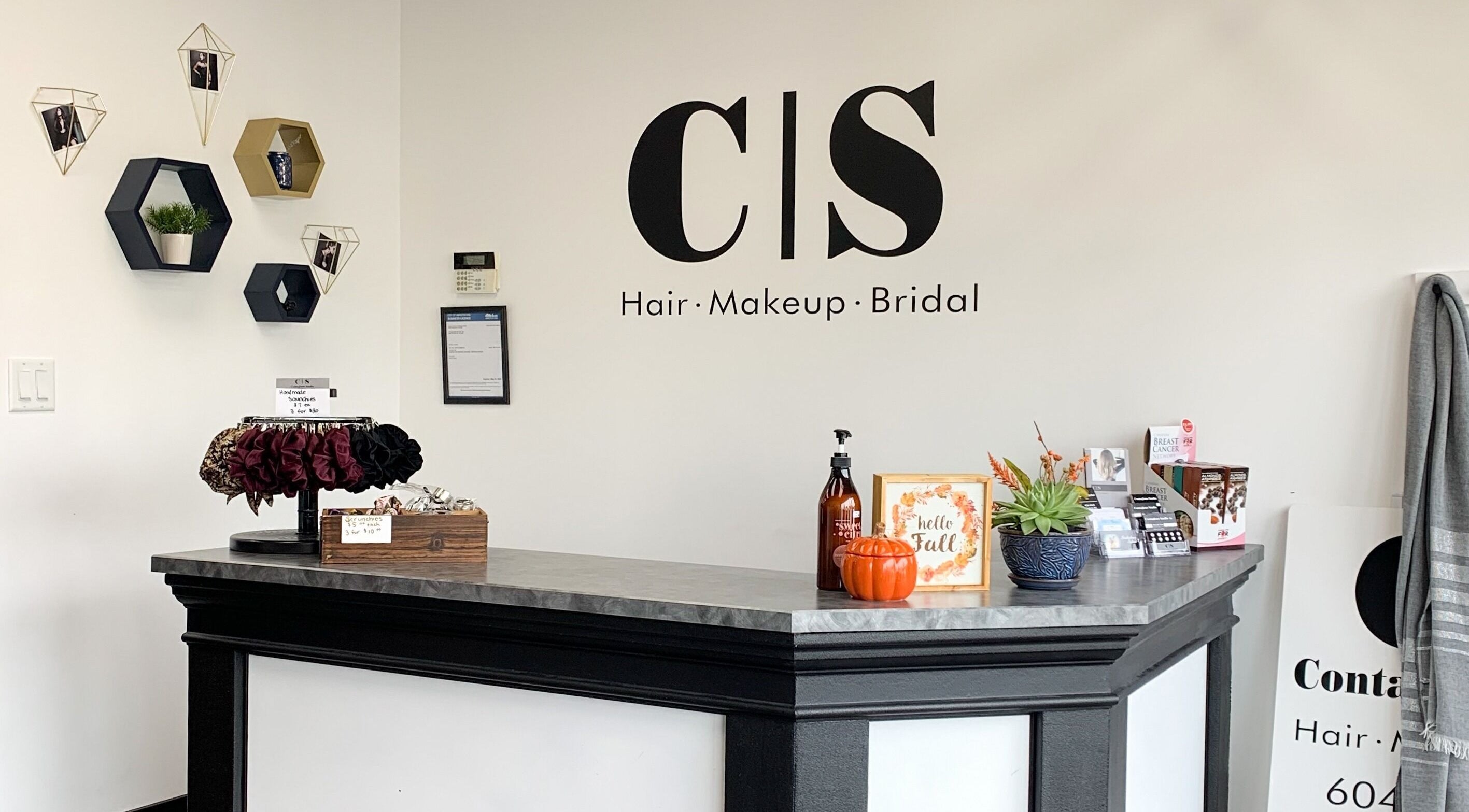 Reception desk at Contagious Studio, Abbotsford, BC, CA with elegant wall decor and a welcoming vibe.