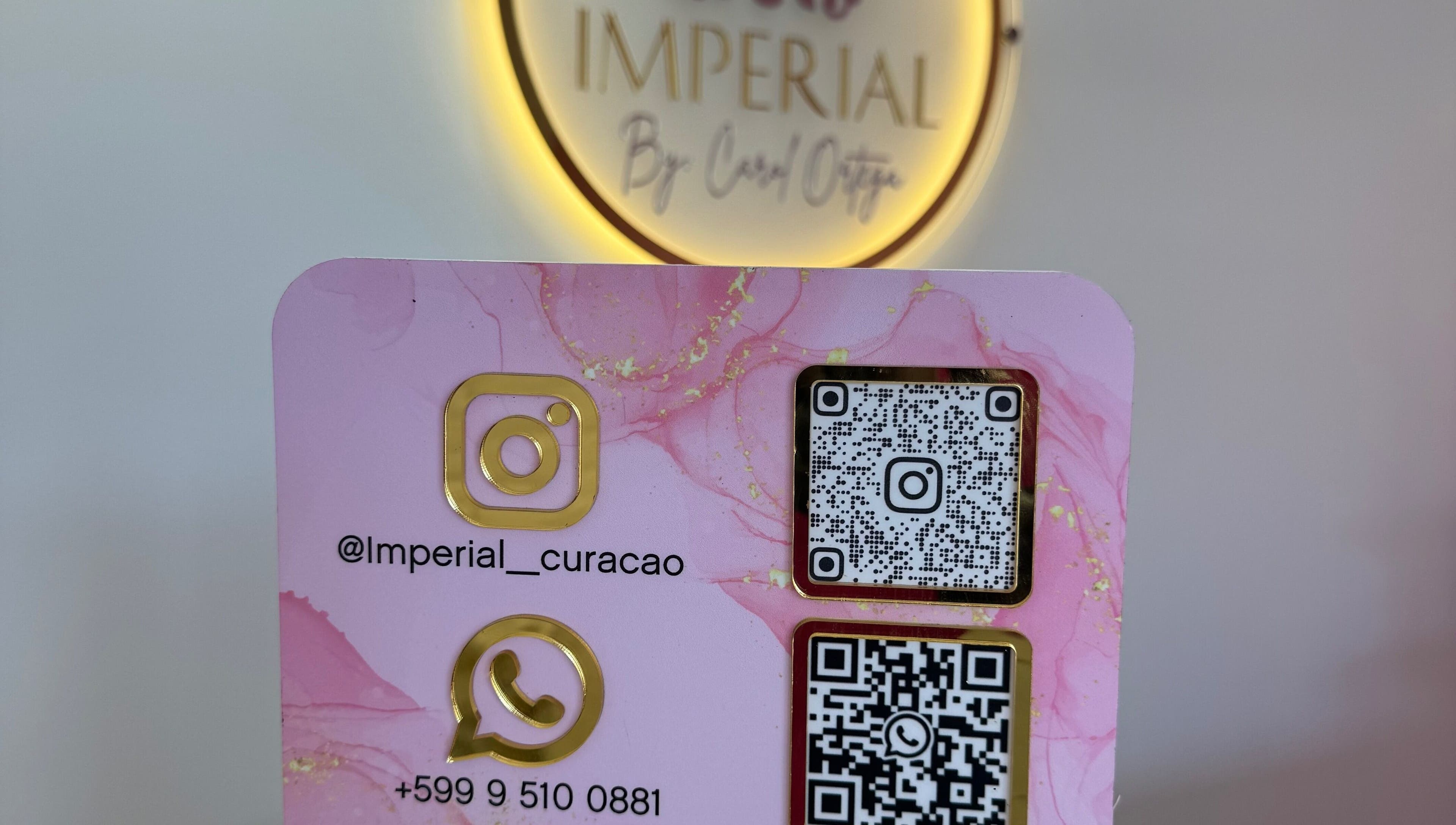 Contact card at Imperial Curacao in Willemstad, Curaçao featuring WhatsApp and Instagram QR codes.