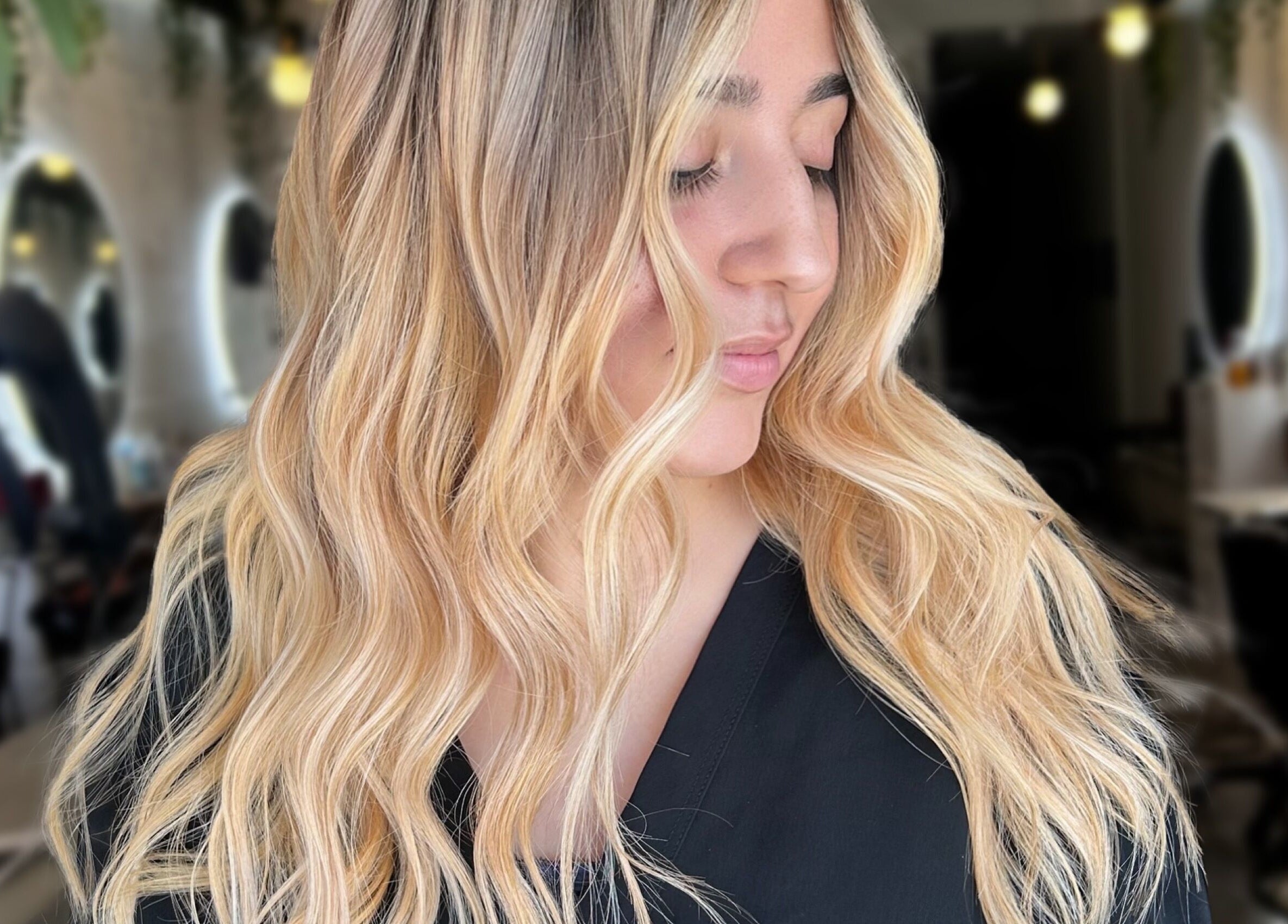 Blonde wavy hairstyle at Styled By Elicia in West Covina, California, US salon ambiance.