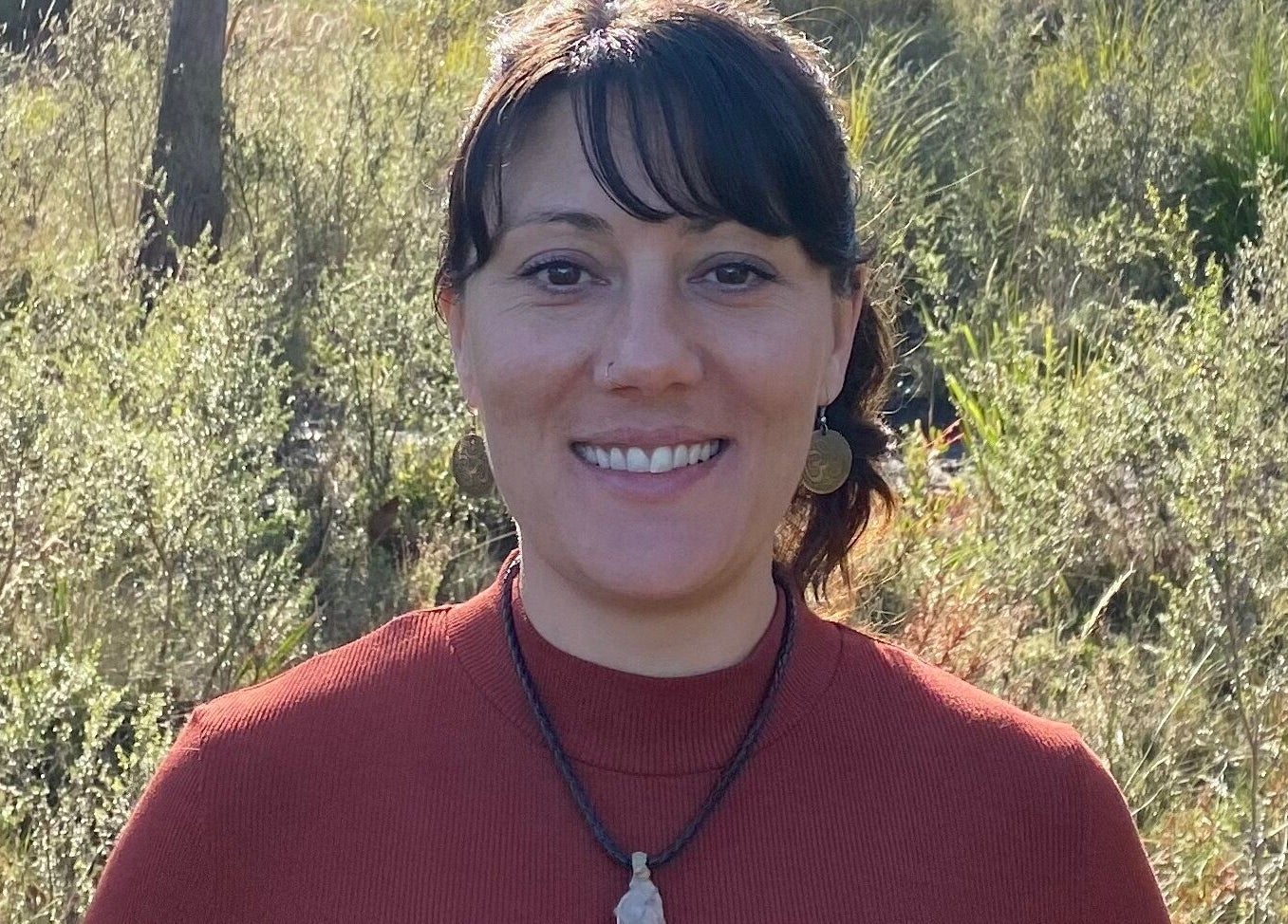 Woman smiling in nature at Relax & Bloom, Kettering, Tasmania, AU.