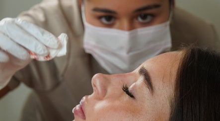 Facial treatment at Moriah Aesthetics, Bournemouth, England, GB. Close-up of aesthetician and relaxed client.