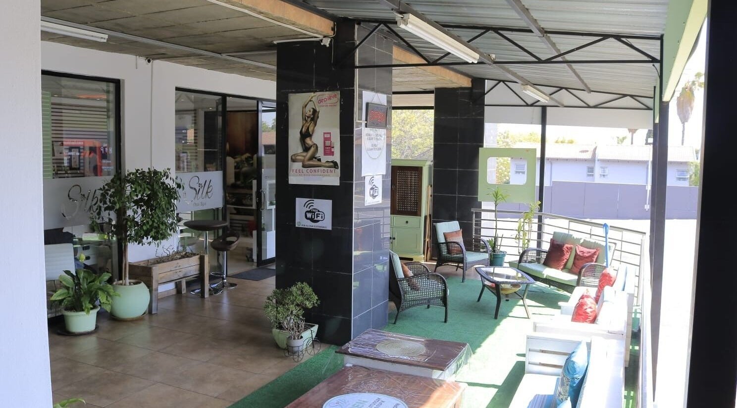 Charming outdoor lounge at Silk Day Spa, Sandton, Gauteng, ZA with cozy seating and lush plants.
