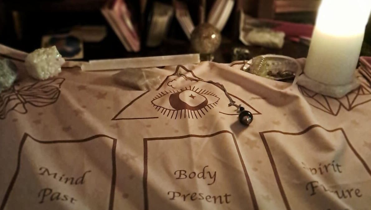 Mystical divination setup at SpiritualMessagesCC, Glasgow, United Kingdom, GB with candle and pendulum.