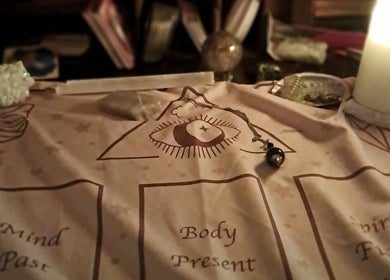 Mystical divination setup at SpiritualMessagesCC, Glasgow, United Kingdom, GB with candle and pendulum.