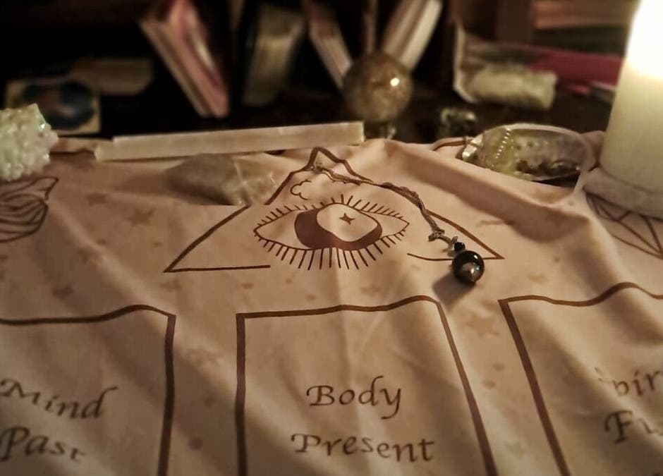 Mystical divination setup at SpiritualMessagesCC, Glasgow, United Kingdom, GB with candle and pendulum.