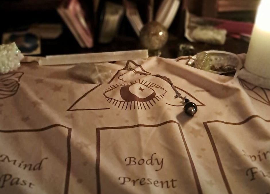 Mystical divination setup at SpiritualMessagesCC, Glasgow, United Kingdom, GB with candle and pendulum.