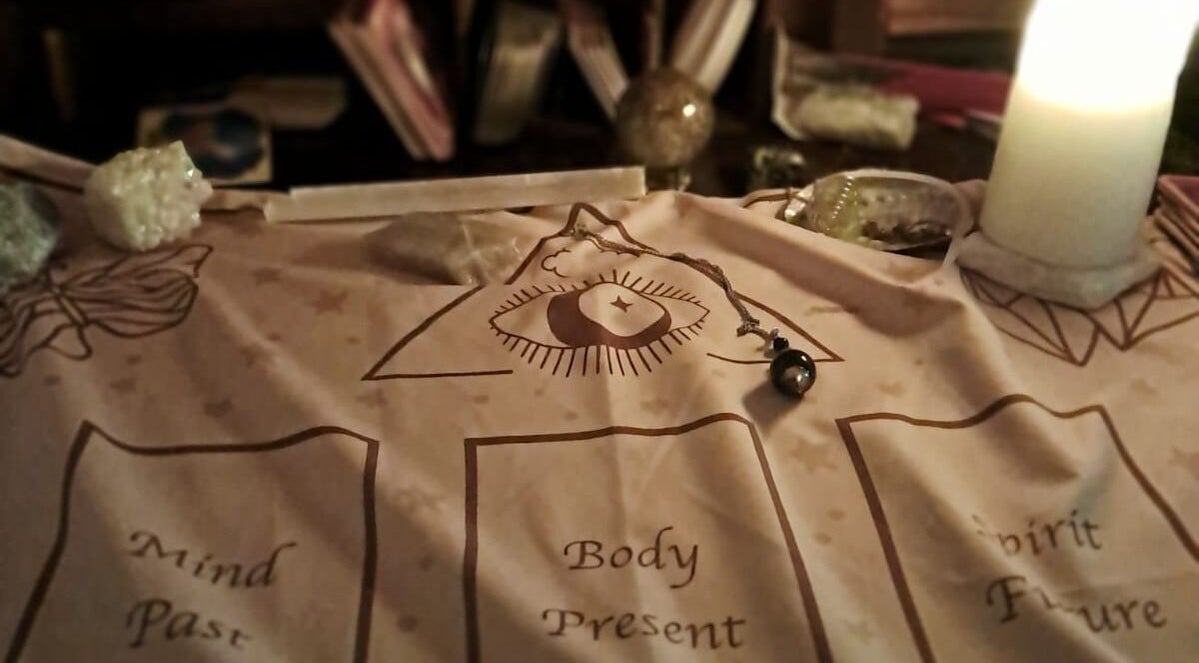 Mystical divination setup at SpiritualMessagesCC, Glasgow, United Kingdom, GB with candle and pendulum.