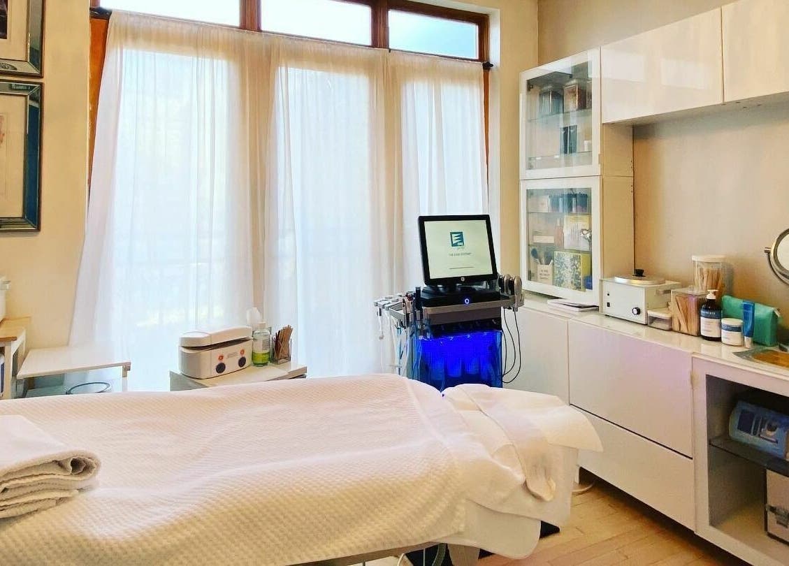 Bright treatment room at Dynamic Salon Spa Studios in Chicago, Illinois, US, featuring a massage table and beauty equipment.