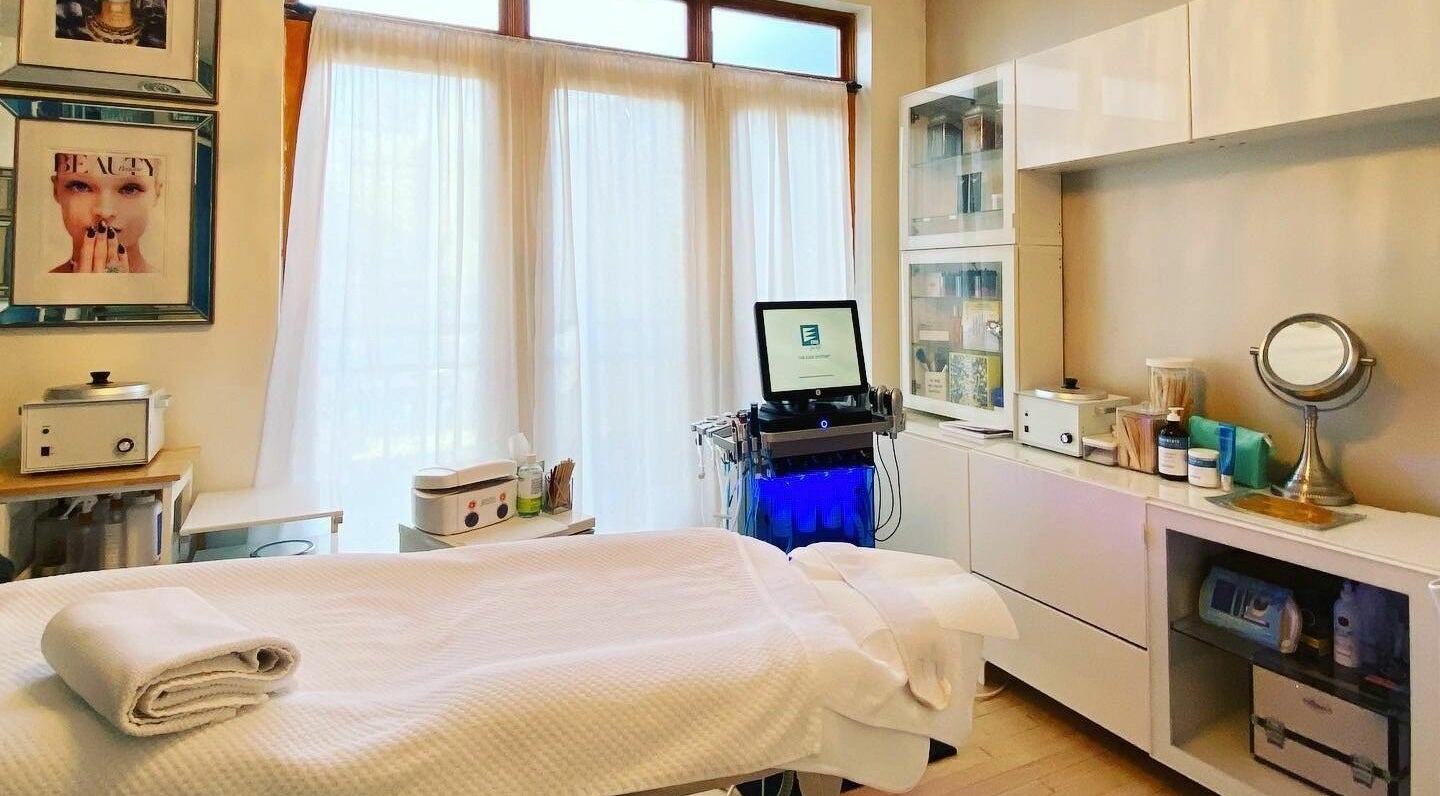 Bright treatment room at Dynamic Salon Spa Studios in Chicago, Illinois, US, featuring a massage table and beauty equipment.