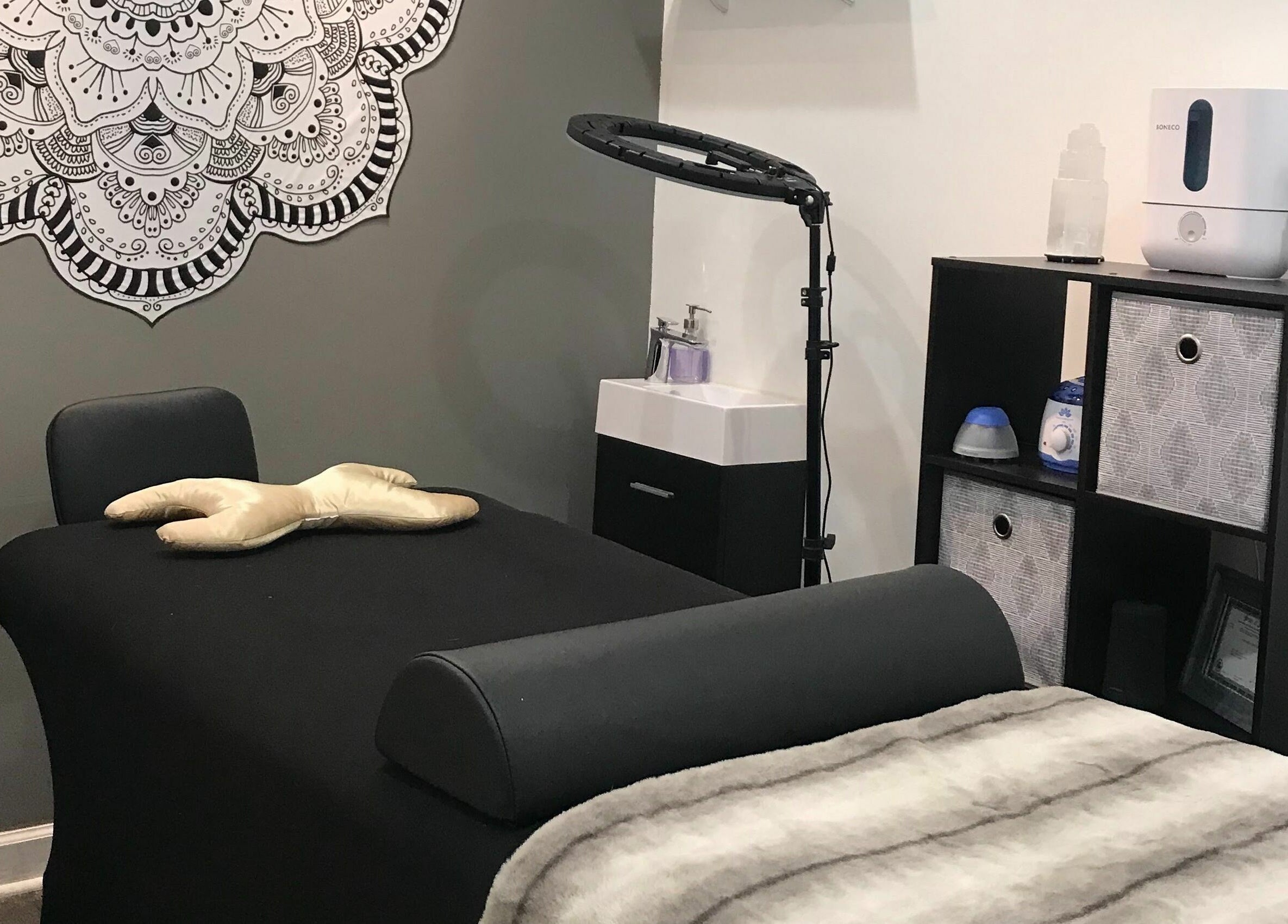 Relaxing massage room at Dynamic Salon Spa Studios in Chicago, Illinois, US with a black massage table and decor.