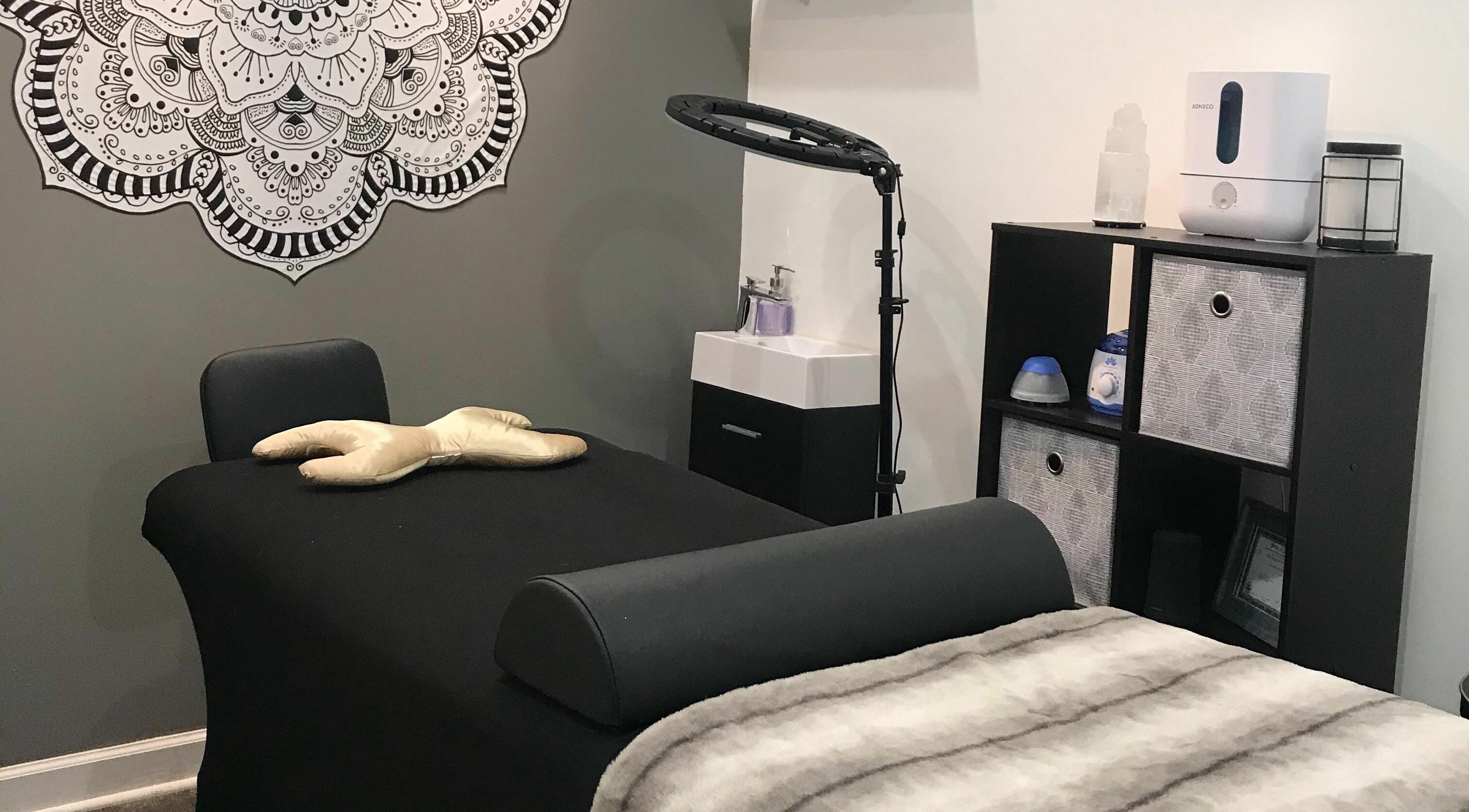Relaxing massage room at Dynamic Salon Spa Studios in Chicago, Illinois, US with a black massage table and decor.