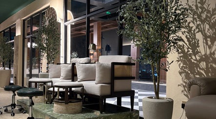 Luxurious seating area at The Beauty Loft Hair Salon and Spa in Jeddah, SA, featuring chic decor and greenery.