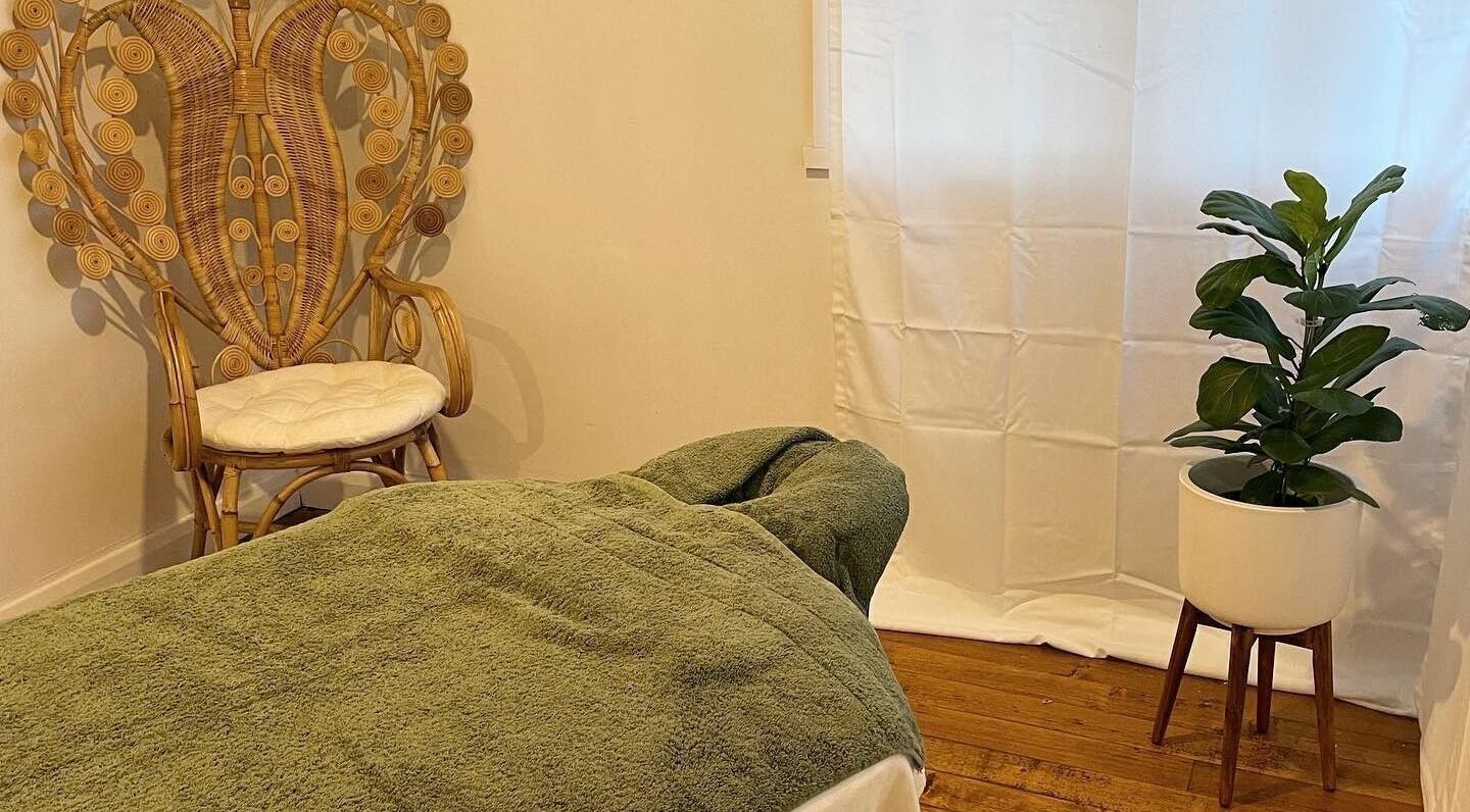 Cozy massage room at Moana Massage Studio & Spa, Lauderdale, Tasmania, AU with green towel and plant decor.