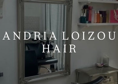 Chic interior of Andria Loizou Hair in London, England, GB, showcasing a vintage mirror and stylish shelves.