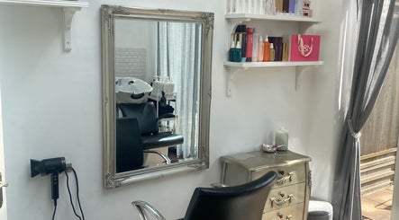 Chic salon interior at Andria Loizou Hair, London, England, GB featuring a mirror, styling chair, and products.