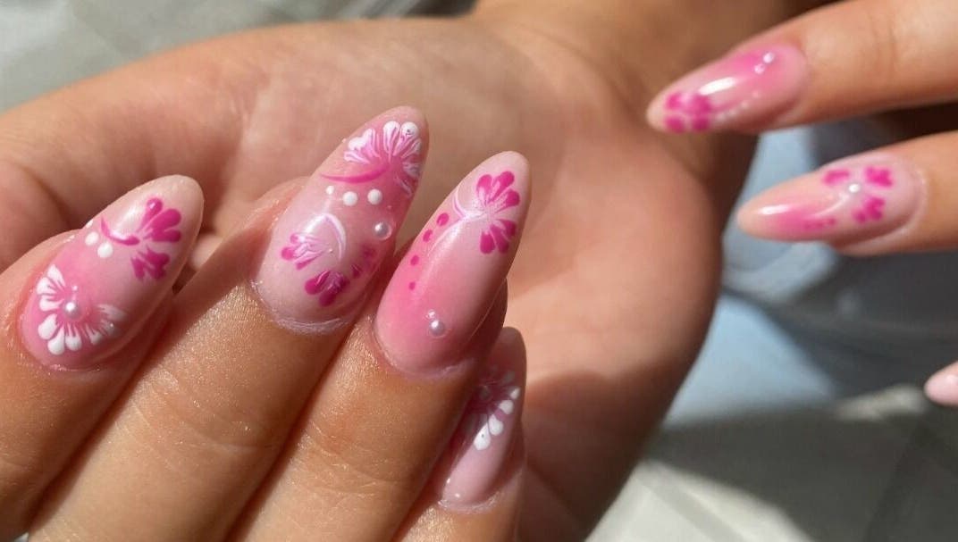 Elegant floral nail art at Hienie's in Brentwood, England, GB, showcasing delicate pink and white designs.