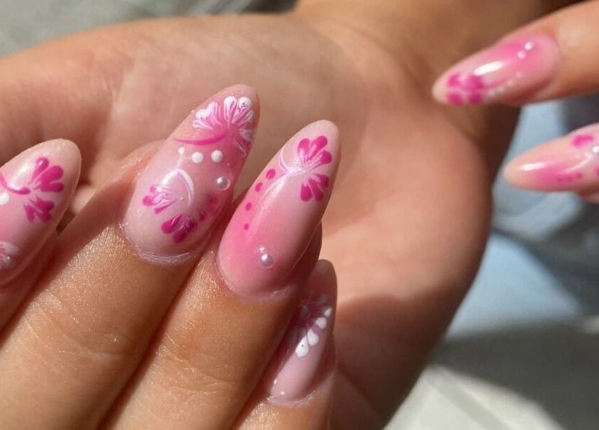 Elegant floral nail art at Hienie's in Brentwood, England, GB, showcasing delicate pink and white designs.