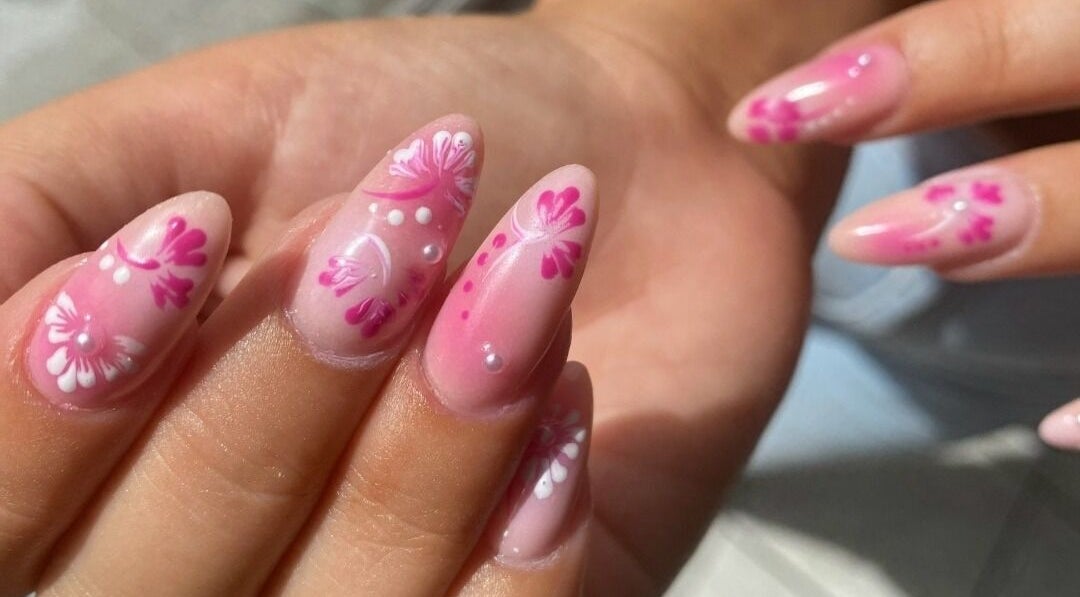 Elegant floral nail art at Hienie's in Brentwood, England, GB, showcasing delicate pink and white designs.