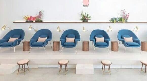 Elegant seating area at Amore Nails and Beauty, Cape Town, Western Cape, ZA showcasing blue chairs and plants.