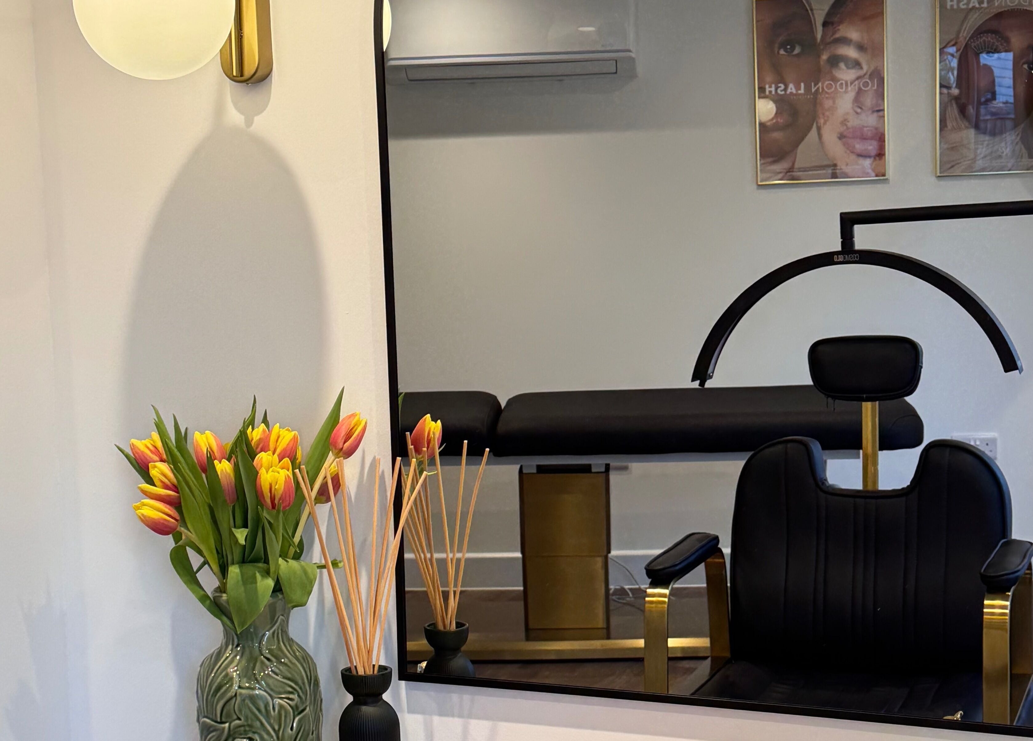 Chic salon interior with mirror, chair, and flowers at Refine by Abbie Baker in Wouldham, GB.