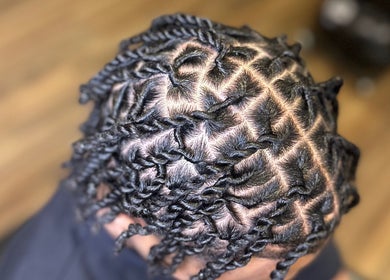 Coiffure tressée réalisée à Martinez Styles, Laval, Québec, CA, mettant en valeur des motifs complexes.