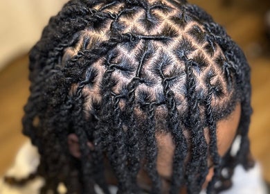 Coiffure soignée de tresses à Martinez Styles, Laval, Québec, CA, montrant des motifs complexes.