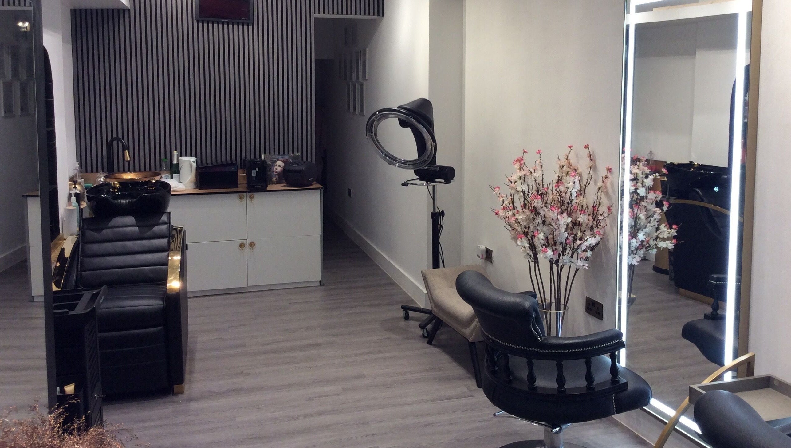 Elegant salon setup at Just Gorgeous by Paty Silva, London, England, GB. Modern decor with black leather chairs.