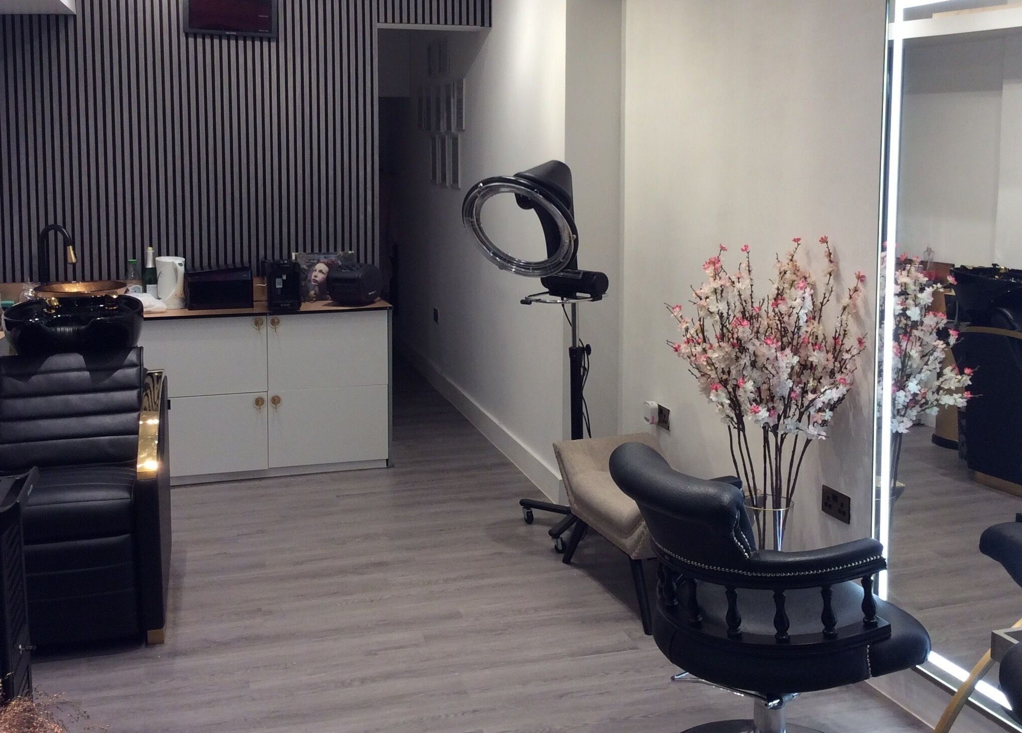 Elegant salon setup at Just Gorgeous by Paty Silva, London, England, GB. Modern decor with black leather chairs.
