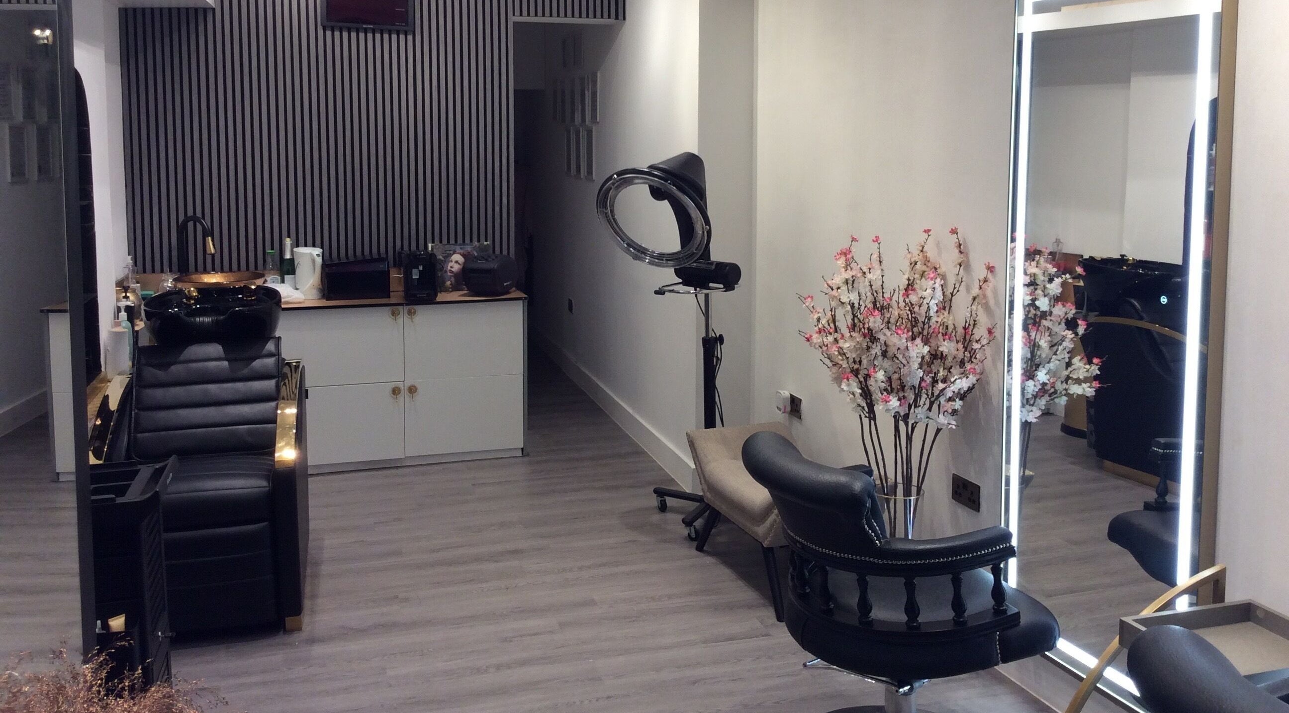 Elegant salon setup at Just Gorgeous by Paty Silva, London, England, GB. Modern decor with black leather chairs.