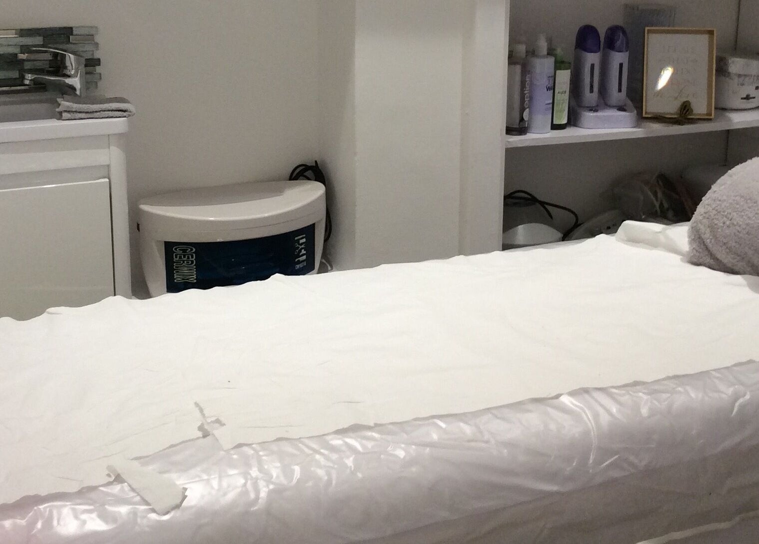 Cozy treatment room at Just Gorgeous by Paty Silva, London, England, GB with a white massage bed.