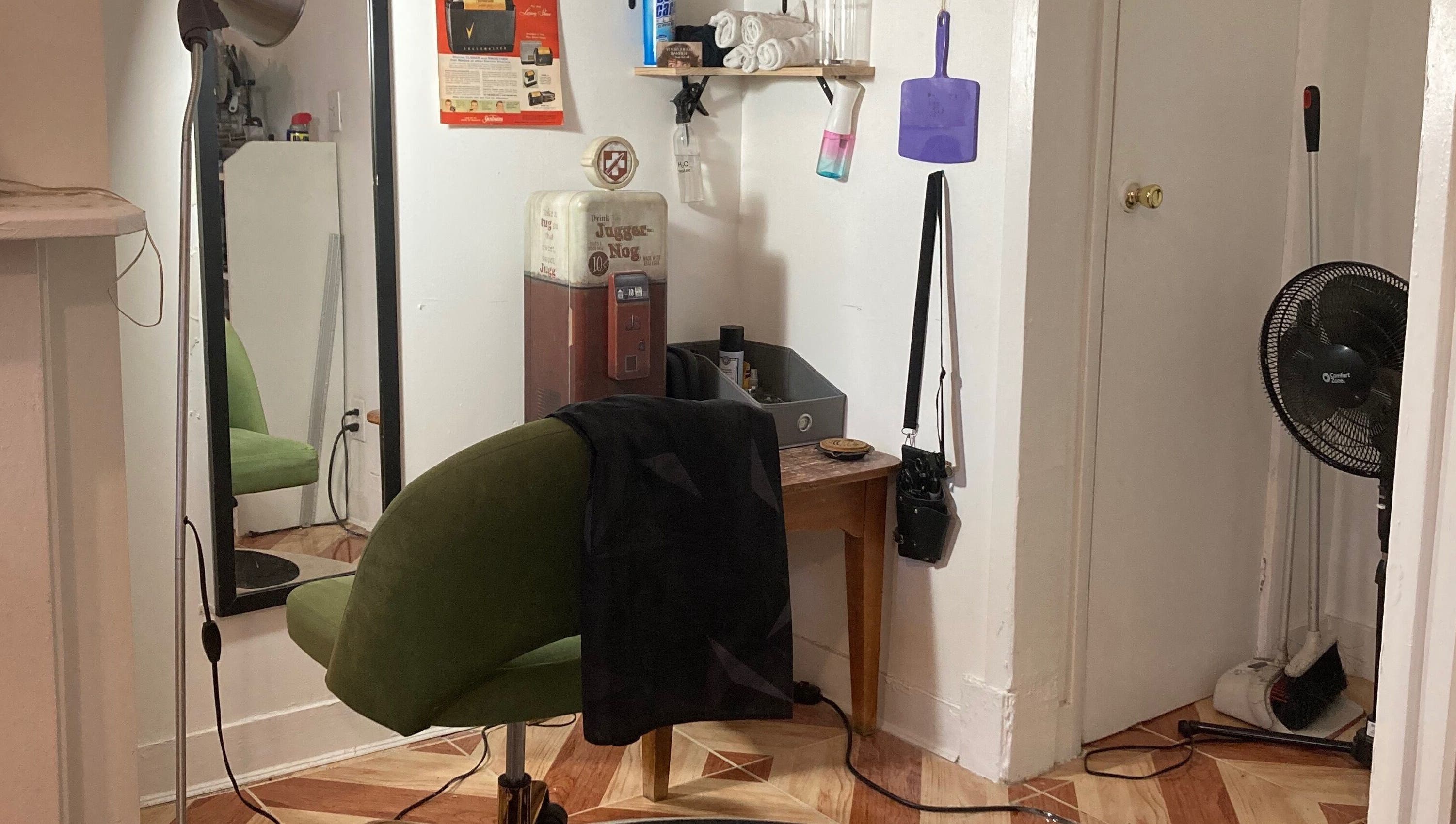 Cozy barber corner at Your Queer Barber, New York, New York, US with green chair and retro decor.