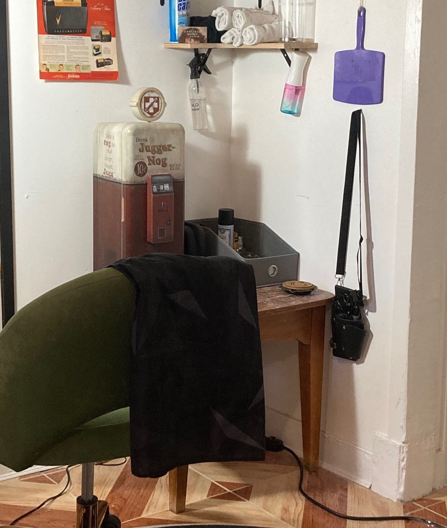 Cozy barber corner at Your Queer Barber, New York, New York, US with green chair and retro decor.