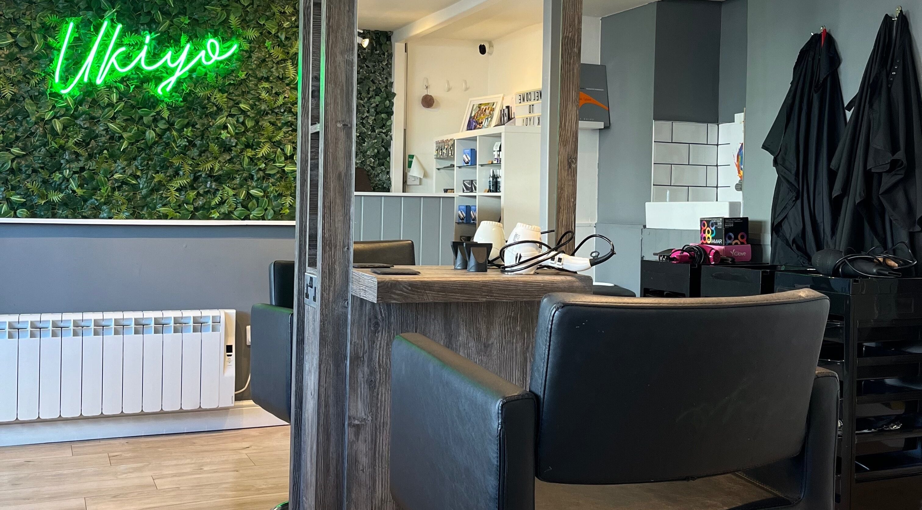 Interior of Hair By Rosie at Ukiyo, Easton, England, GB with green wall and modern styling chairs.