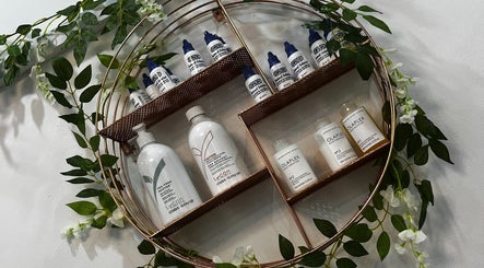 Stylish shelf at Monria Hair and Beauty Salon, St. Albans, England, GB, showcasing beauty products and greenery décor.