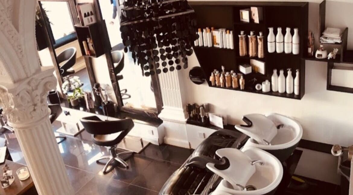 Interior of Hair by Daria Grosu salon in Bristol, England, GB, showcasing chic styling stations and wash basins.