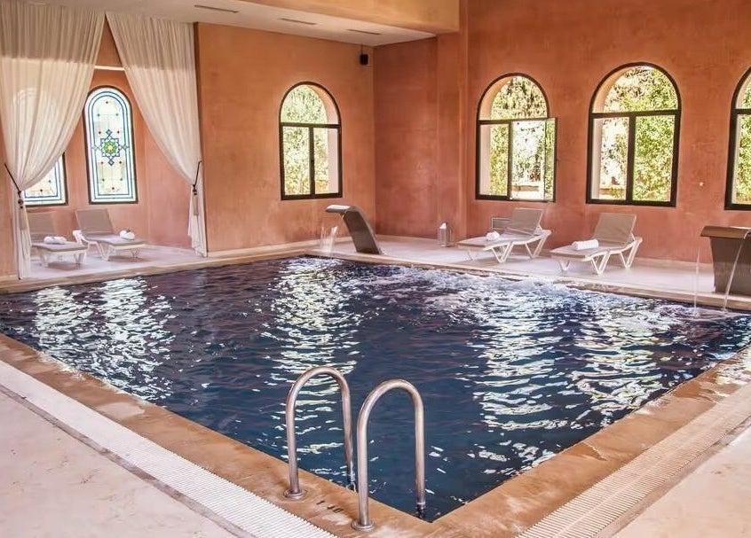 Intérieur de Wud Spa à El Bour, Marrakesh-safi, MA, avec piscine élégante et chaises longues.
