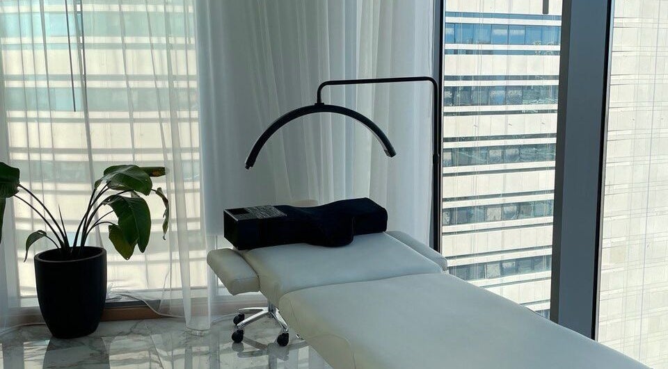 Spa treatment room at Re:Vision Studio, لوسيل, بلدية الضعاين, QA, featuring a massage table and plant.