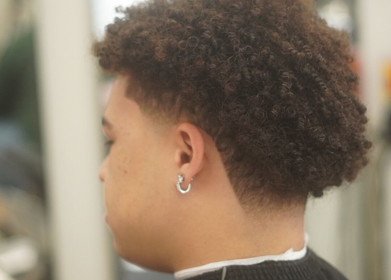 Curly haircut with fade at Reezy at Blurry Boy$ Club, Pleasant Grove, Utah, US.