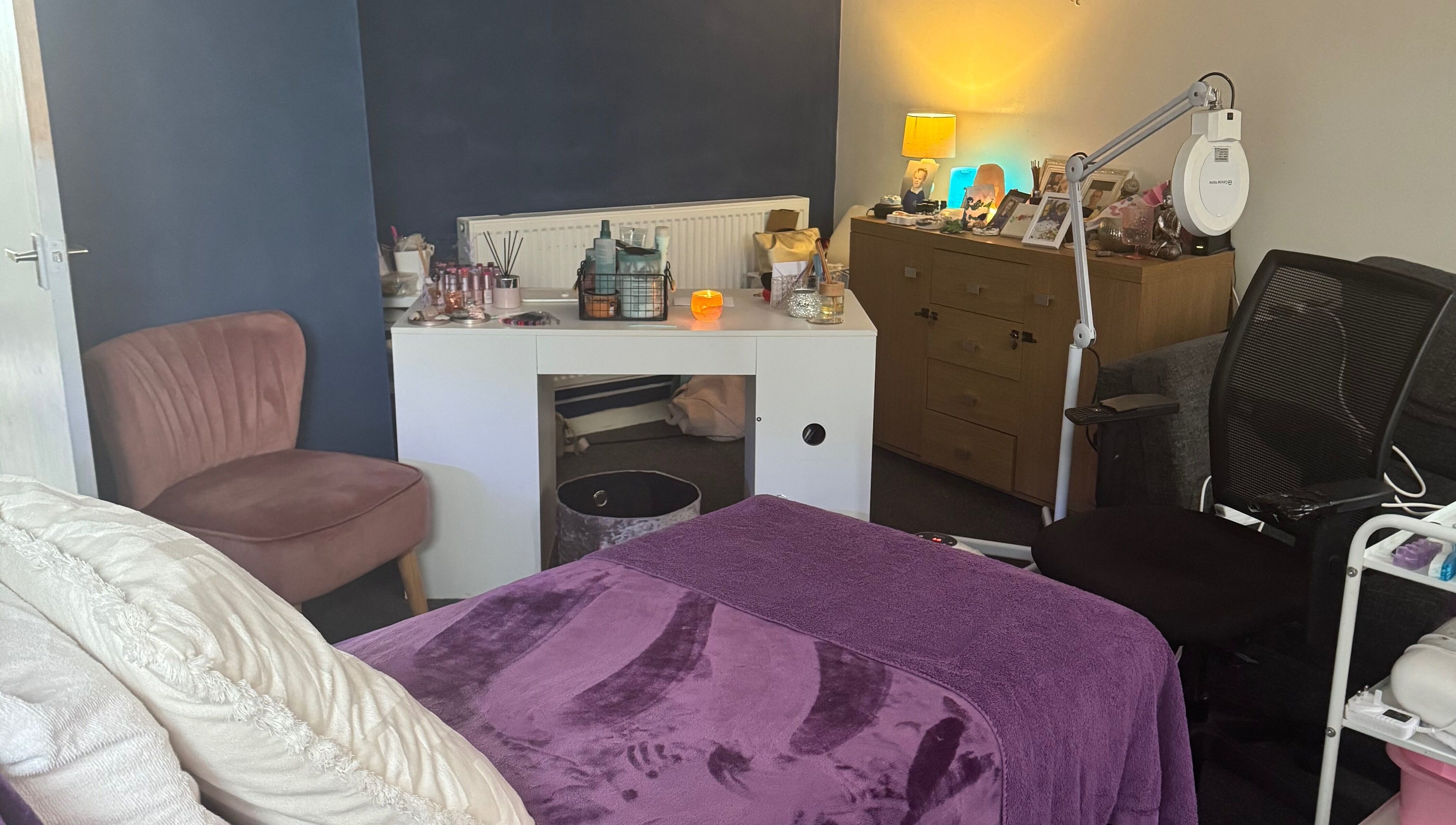 Cozy Beautylicious treatment room in Poole, England, GB with plush bed and ambient lighting.